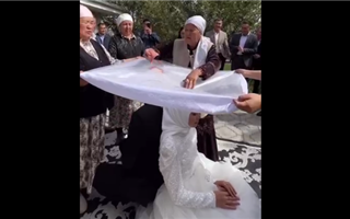 Казахстанцев озадачило видео, на котором жениху и невесте трут головы сырым мясом
