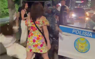 Алматинский полицейский уронил иностранку на землю - видео