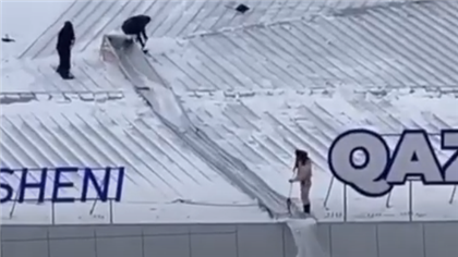 "Летающие казахи" - казахстанцы обсуждают работников, которые  счищают снег с крыши без страховки